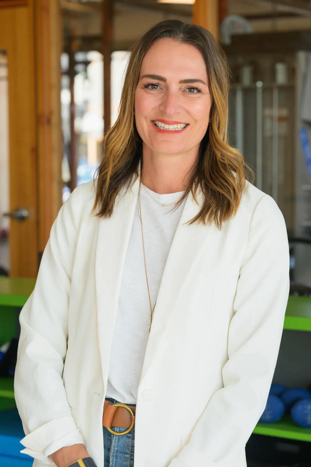 Dr. Milica McDowell wearing a white jacket in an indoor fitness studio.